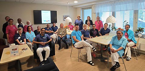 Cirka 25 medarbetare som tittar in i kameran. 